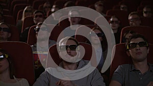 Spectators in 3d glasses watching film in cinema. People in 3d glasses