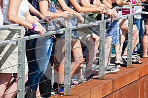 Spectators standing at a handrail