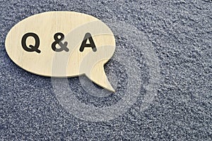 Speech bubble with Q and A on concrete background.