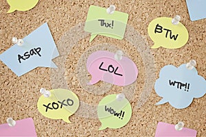 Speech bubbles with chat abbreviations on pinboard