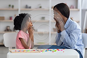 Speech-language pathologist having lesson with little girl