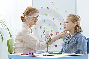 Speech therapist exercising with child photo