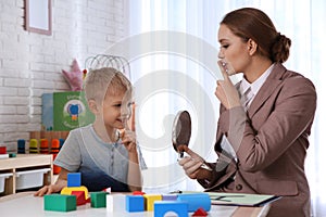 Speech therapist working with boy in office