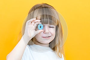 Speech therapy. Toddler girl holding the letter O in her hands. Classes with a speech therapist. Girl on isolated yellow