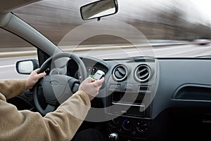 Driver using cell phone in car blurred motion