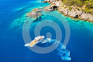 Speed boat in blue sea at sunrise in summer. Aerial view