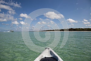 Speed boat in front of Kayak on crystal clear ocean water of Delnor Wiggins State Park of Naples photo