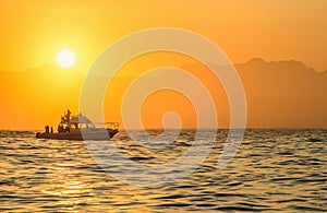 Speed boat in the ocean at sunrise