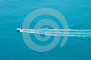 Speed boat sailing fast on the surface of the blue sea.