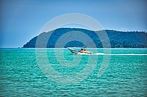 Speed boat on the waves of the azure Andaman sea under the blue sky near the shores of the sandy beautiful exotic and stunning