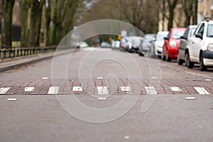 Speed bump on empty street in Warsaw, Poland, cars on one side of the street, challenge symbol