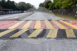 Speed bump or road hump in yellow and black stripe to slow down vehicles and promote road safety