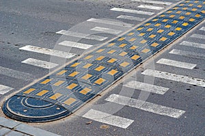 Speed bump and road markings on the pavement.