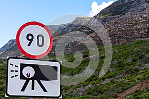 Speed and camera trap road sign with mountain background.
