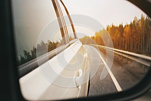 Speed car driving, view from the mirror on an empty highway, motion blur closeup