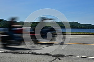 Speed concept - Motorcycles speeding past lake