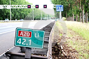 Speed and distancee sign at motorway A20 at 42,1 left where speed is in kilometers with red crosses above driving lanes.