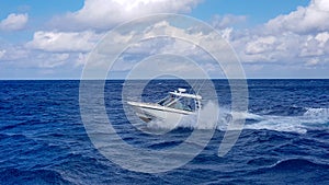 Speed fishing tender boat jumping the waves in the sea and cruising the blue ocean day in Bahamas. Blue beautiful water