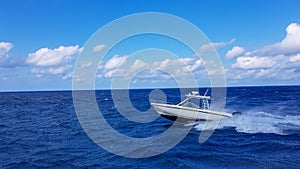 Speed fishing tender boat jumping the waves in the sea and cruising the blue ocean day in Bahamas. Blue beautiful water