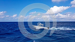 Speed fishing tender boat jumping the waves in the sea and cruising the blue ocean day in Bahamas. Blue beautiful water