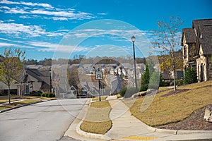 Speed limit at 25 miles on residential street leading down steep hill, row of two-story houses, new development subdivision