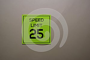 Speed Limit 25 write on a sticky note isolated on office desk