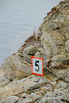 Speed limit 5 knots sign by the sea..