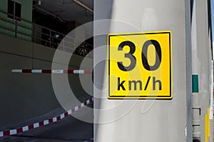 Speed limit 30km/h traffic sign on yellow on building