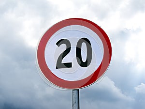 Speed limit sign 20 against cloudy sky