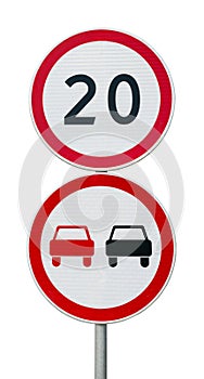 Speed limit sign 20 and no overtaking road sign on a metal pole.