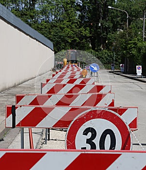 Speed limit sign and hurdles in the road excavation