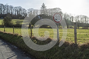 A speed limit sign on a rural road in the countryside in spring