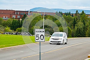 speed limit signboard on the road car in the background