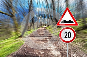 Speed limit and speed bump on Forest road in motion blur on a sun