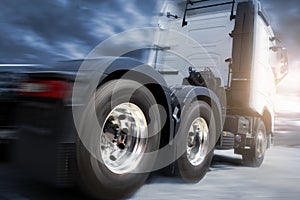 Speed motion blur of semi truck driving with spinning wheels on road. Industry freight truck transportation.