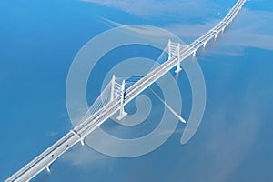 Speed ship passing under large cable stayed bridge aerial view