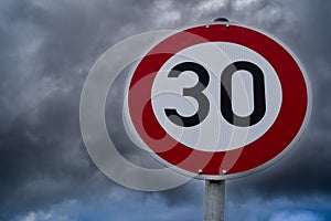 Speed sign 30 kilometers per hour with cloudy sky in the background