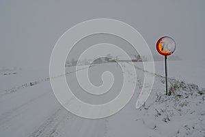 speed sign with 70 kph covered in snow