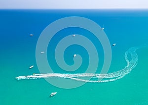 Speedboat leaves spray trail on sea water. Watersports at seaside, aerial seascape