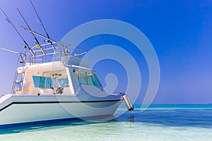 Speedboat for tropical fishing yacht on blue sea background with fishing rods and lines