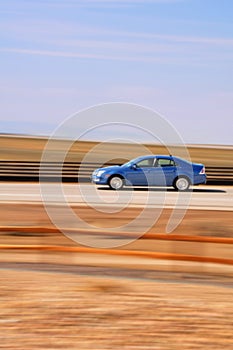 Speeding Blue Car with Blurred Background