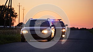 Speeding Driver Gets Pulled Over By Police Patrolling Car . Wide Shot of the Two Cars Stopped in a
