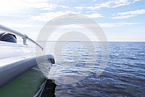 Speeding fishing motor boat with drops of water. Blue ocean sea water wave reflections with fast fishing yacht. Motor boat in the