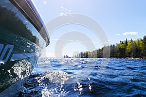 Speeding fishing motor boat with drops of water. Blue ocean sea water wave reflections with fast fishing yacht. Motor boat in the