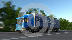 Speeding freight semi truck with MADE IN CANADA caption on the trailer