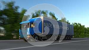 Speeding freight semi truck with MADE IN SOUTH AFRICA caption on the trailer