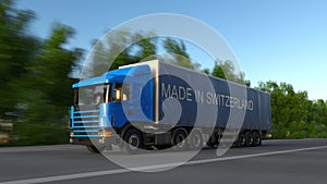 Speeding freight semi truck with MADE IN SWITZERLAND caption on the trailer. Road cargo transportation. 3D rendering