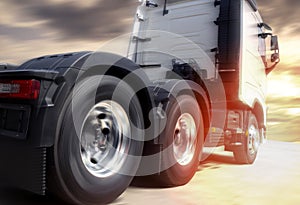 Speeding motion of semi truck on road at sunset sky. Road freight transportation