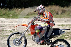 Speeding Moto X bike Rider with blurred background as he rushes past on dirt track