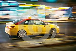 Speeding Taxi Car Fast Driving In City Street. Motion Blur Background